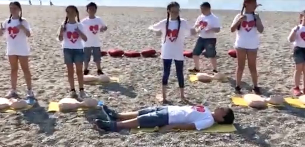 Bambini in spiaggia insegnano le manovre salva-vita