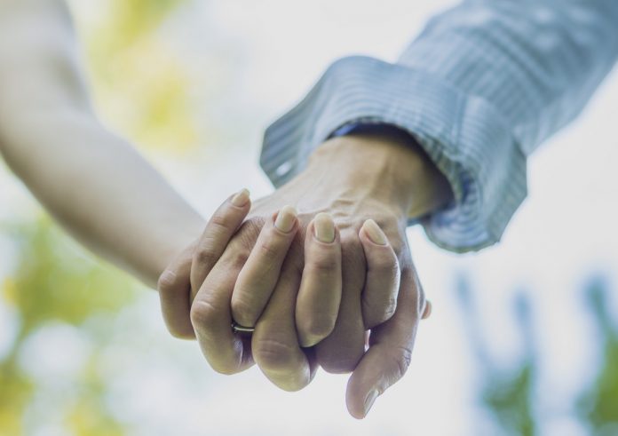 Close up on couple holding hands