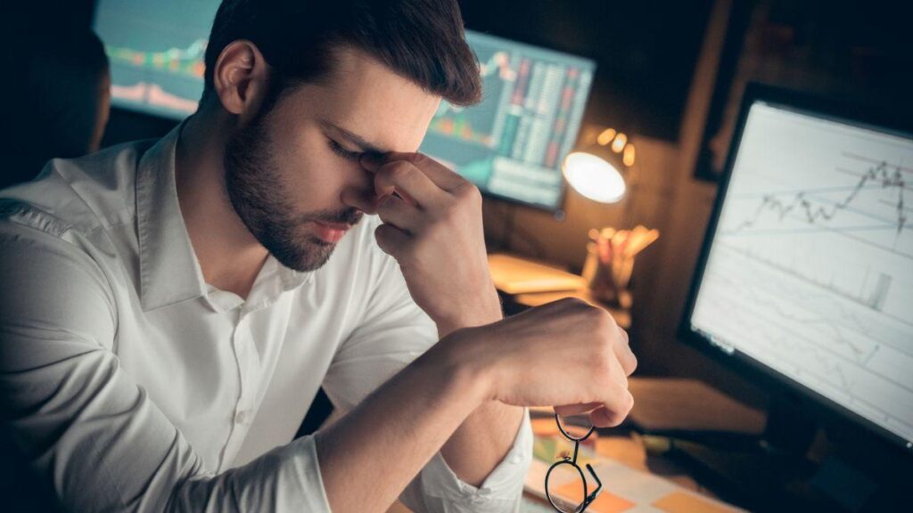 Uomo stanco perché passa troppo tempo davanti al PC.